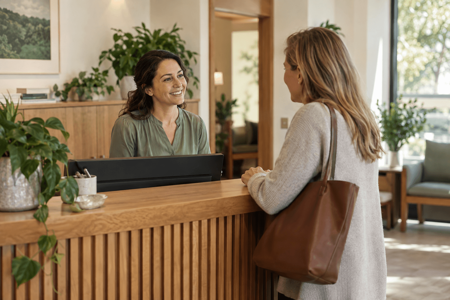 A receptionist welcoming a visitor at a small practice.